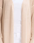 Beige knit sweater worn by a person on a white background