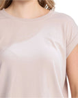Beige t-shirt worn by a person on a white background