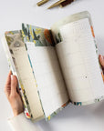 Open planner with floral design on a white surface