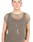 Woman wearing a beige mesh top against a white background