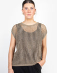 Woman wearing a beige mesh top against a white background