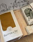 Burrow & Be organic products in packaging on a wooden surface