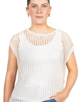 Woman wearing a white mesh top and blue jeans on a white background