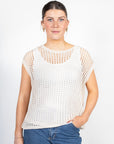 Woman wearing a white mesh top and blue jeans on a white background