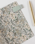 Floral notebook with a gold pen on a white background