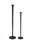 Two dark metal candlestick holders or candlesticks with round bases, one tall and one short, shown on a plain white background.