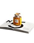 Chanel perfume bottle on an open magazine with a white background