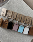 Set of wooden keychains with engraved text on a textured surface
