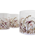 Three glass tumblers with floral and bird design on a white surface