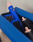 Set of hair styling tools including a blue curling iron and black brushes in an open blue box.