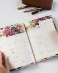 Floral planner with a pen and pencil case on a light surface