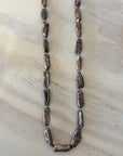 Necklace with brown beads on a light wood surface