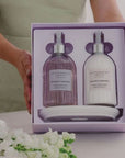 Two bottles of peppermint and eucalyptus body wash in a gift box with a person holding it.