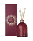 Red diffuser bottle with reeds and packaging on a white background