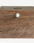 Wooden box with a white knob on a light gray background