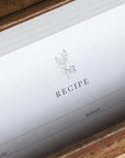 Close-up of a recipe card with a wooden box in the background