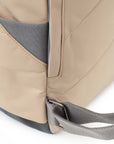 Close-up of a beige backpack with gray straps on a white background