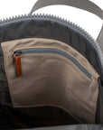 Close-up of a backpack with a zipper and brown interior pocket.