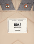 Roka London label on a beige and gray fabric background