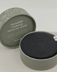 Reusable makeup remover pads in a green container on a light gray background