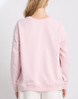 Person wearing a light pink sweatshirt on a white background