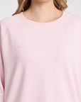 Pink sweatshirt with a brand logo on a light gray background
