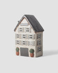 Decorative house-shaped container with a black roof on a white background