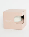 White spherical product in a pink box on a white background