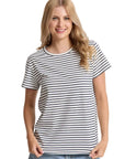 Woman wearing a black and white striped t-shirt and blue jeans on a light gray background