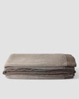 Folded brown blanket on a light gray background