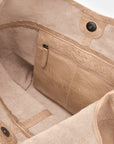 Close-up of a beige bag with visible branding on a light background