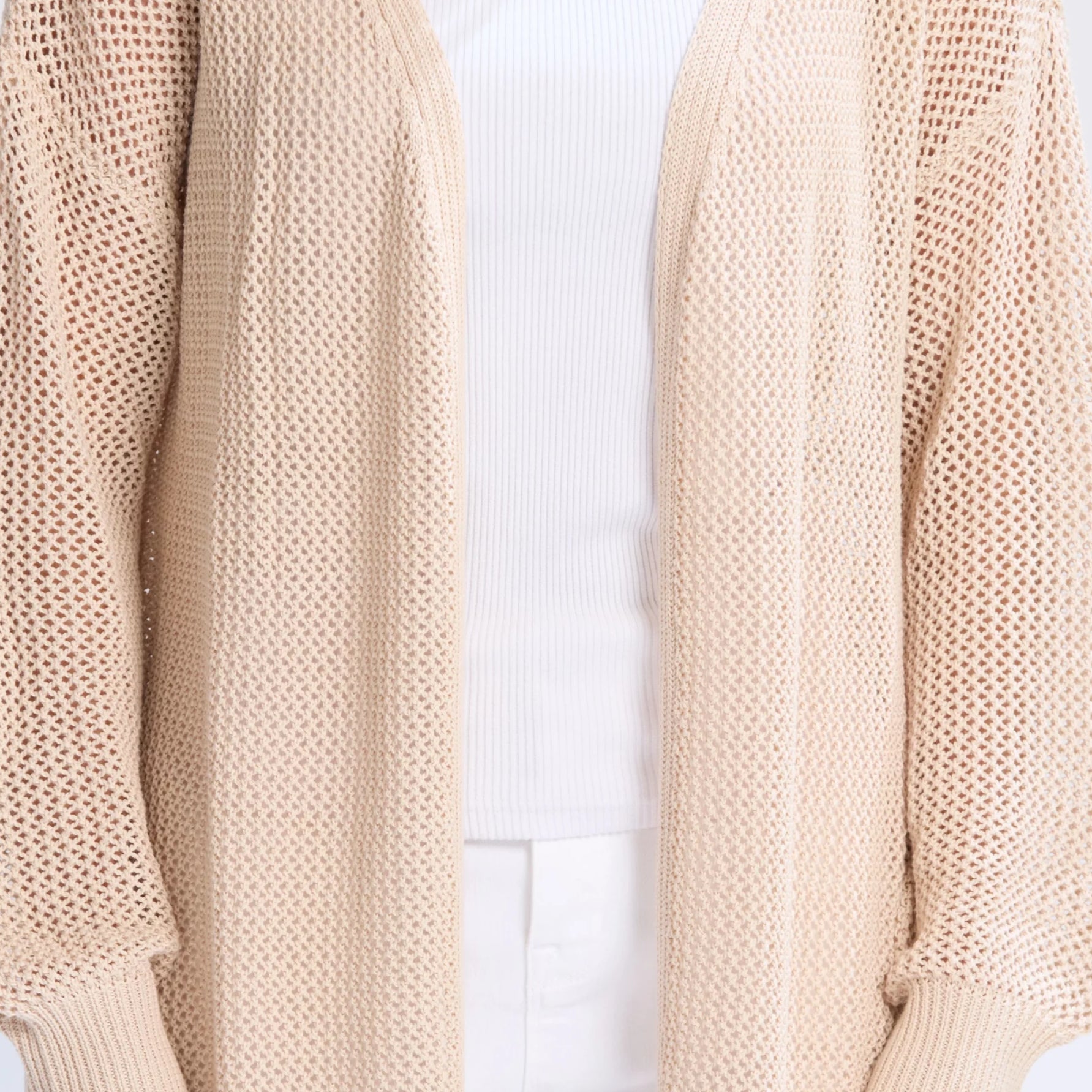 Beige knit sweater worn by a person on a white background