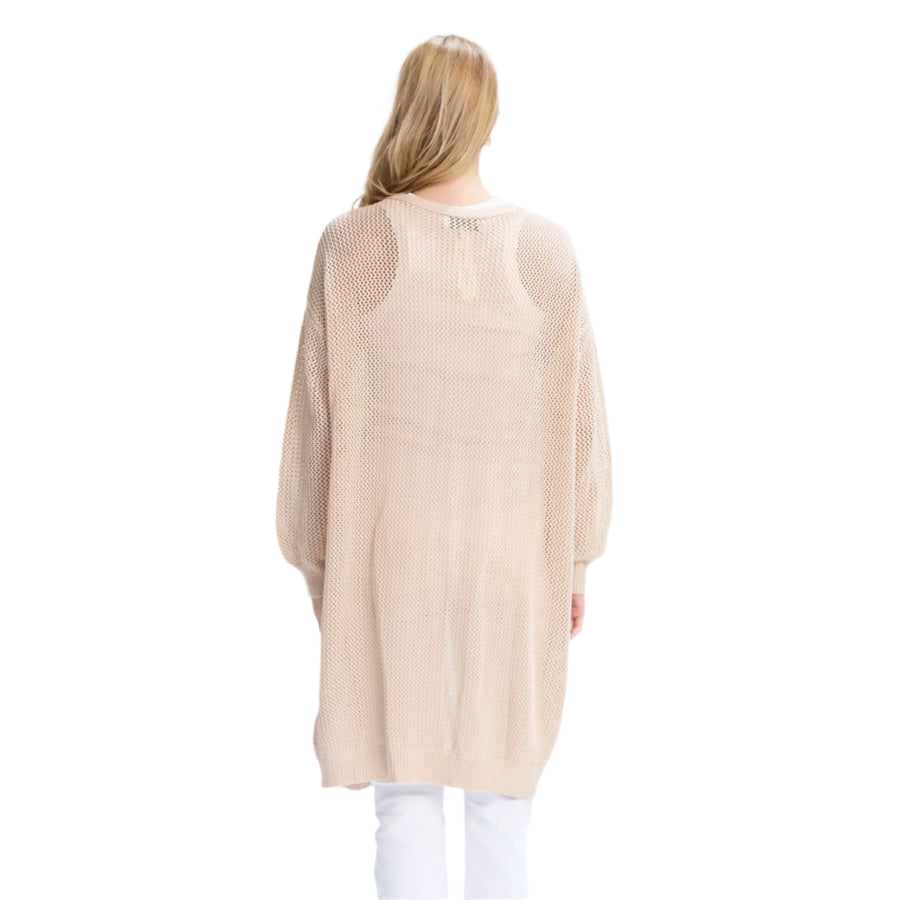 Person wearing a beige cardigan and white pants on a white background
