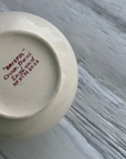 White ceramic jug with 'Bristol' branding on a white gray surface