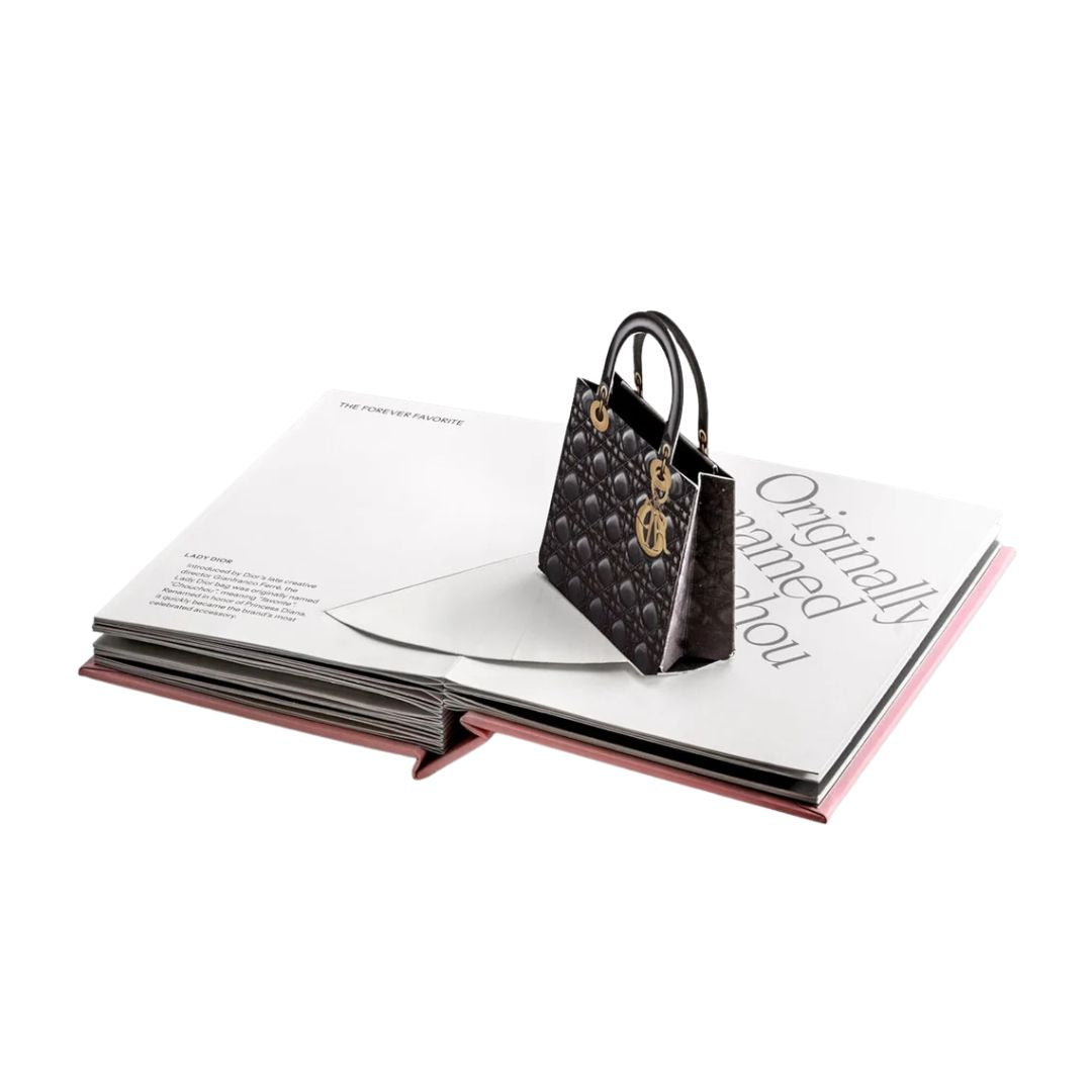 Black handbag with gold accents on an open book