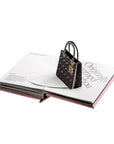 Black handbag with gold accents on an open book