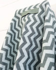 Gray and white chevron patterned blanket draped over a surface.