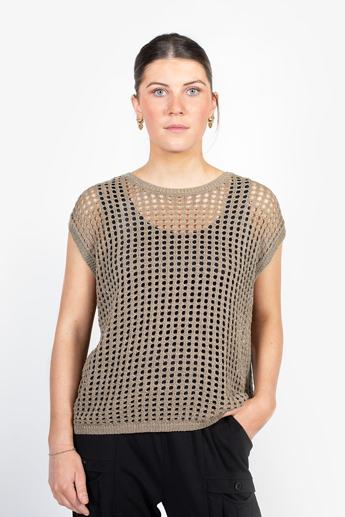 Woman wearing a beige mesh top against a white background