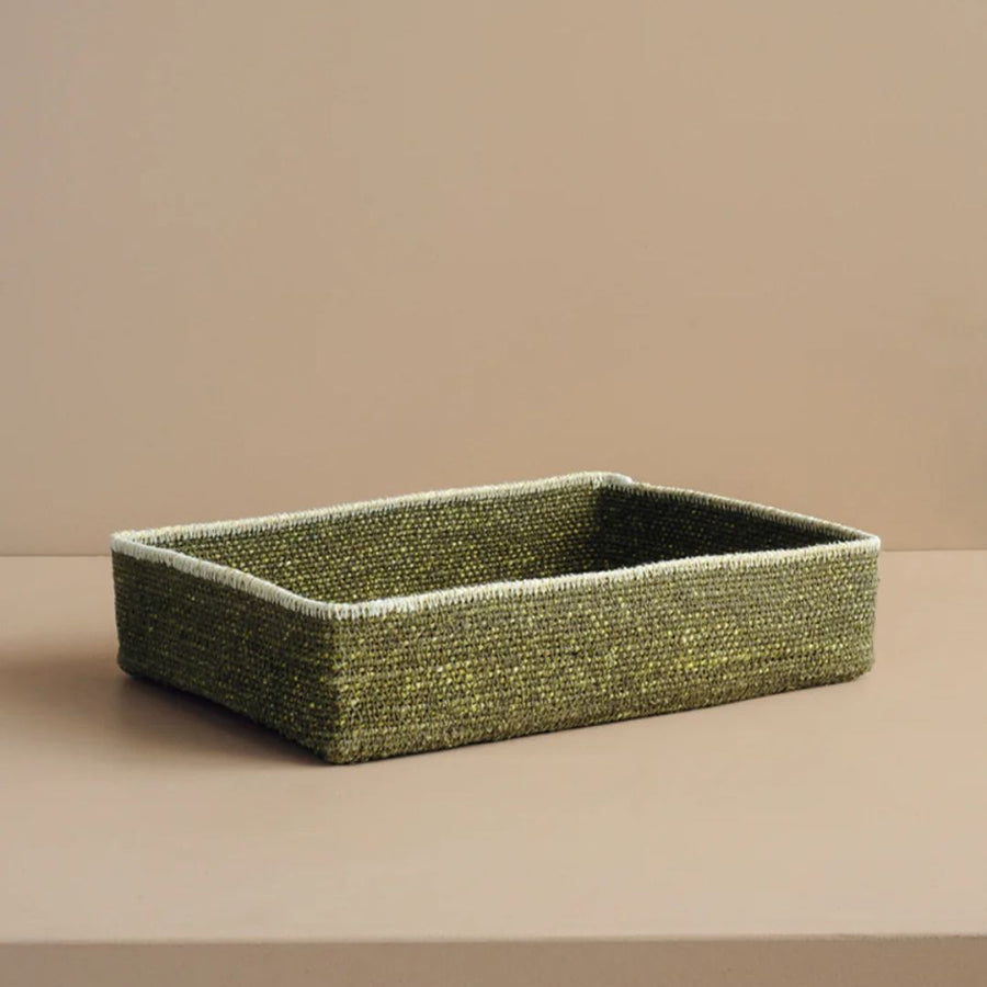 Green woven rectangular basket on a beige background.