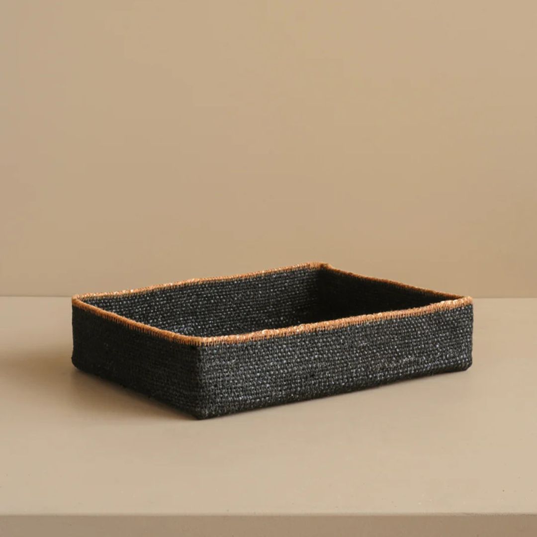 Rectangular black woven basket on a beige background