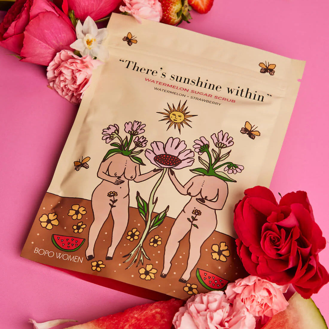 Book titled 'There's Sunshine Within' surrounded by flowers and watermelon on a pink background