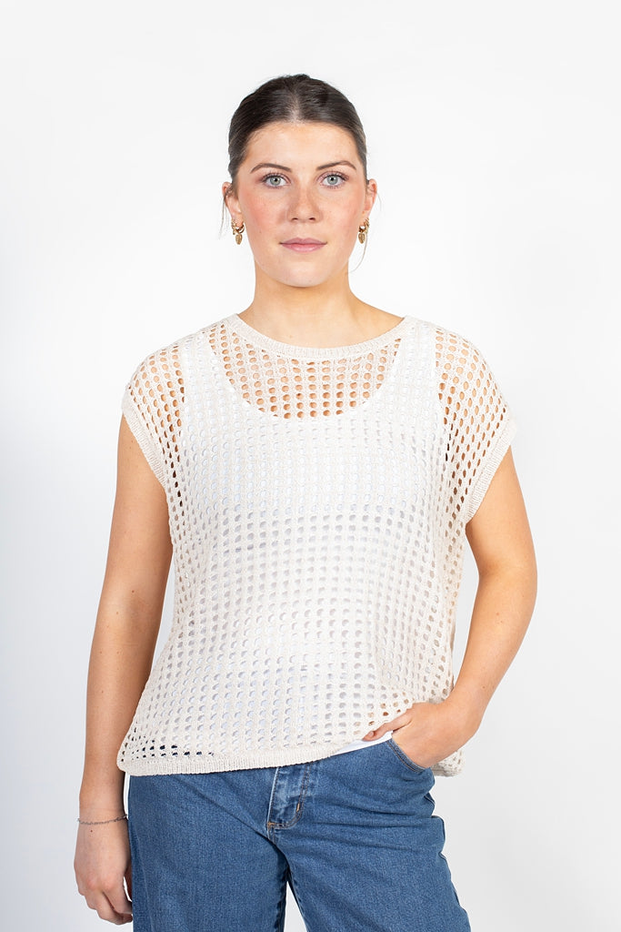 Woman wearing a white mesh top and blue jeans on a white background