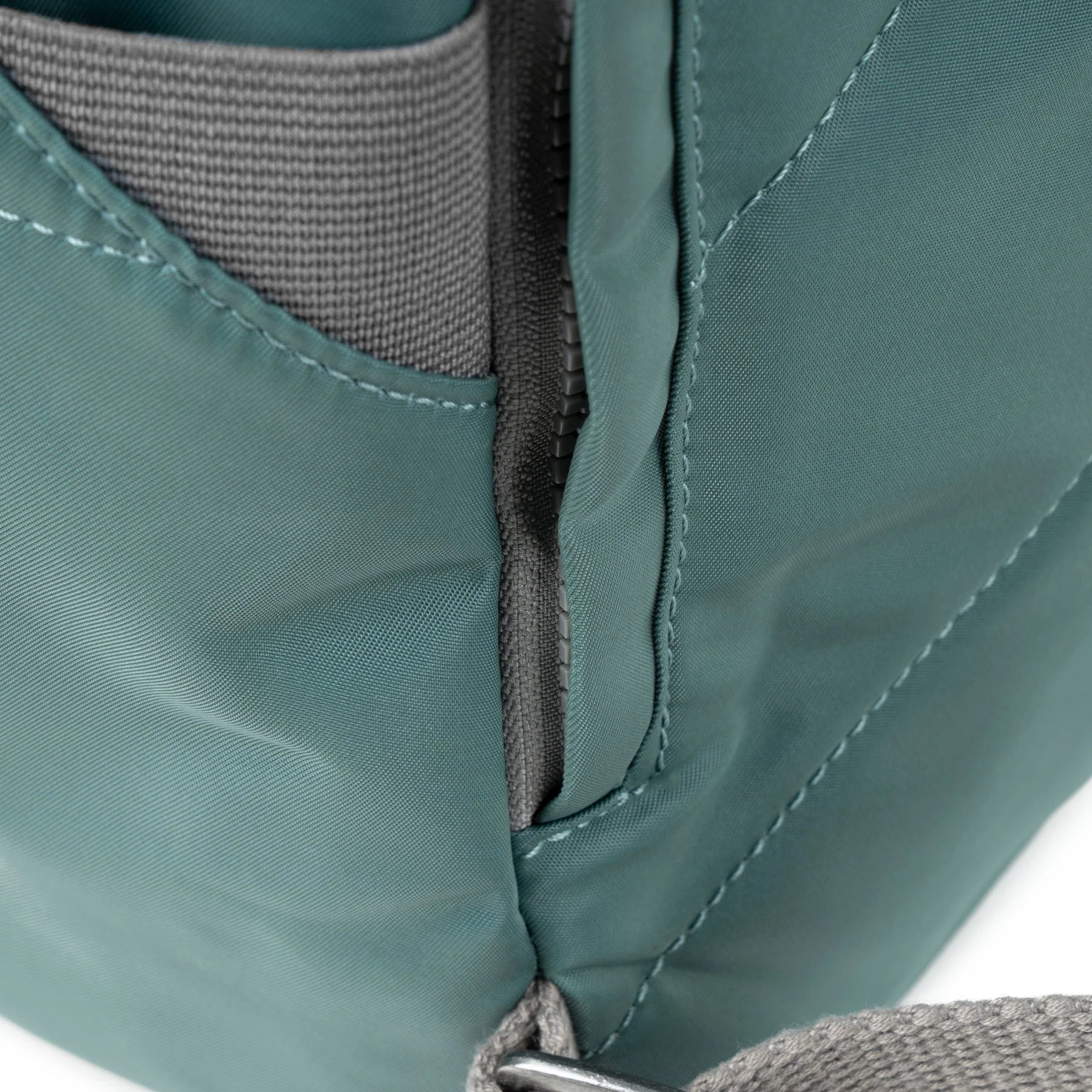 Close-up of teal fabric with gray interior and stitching detail