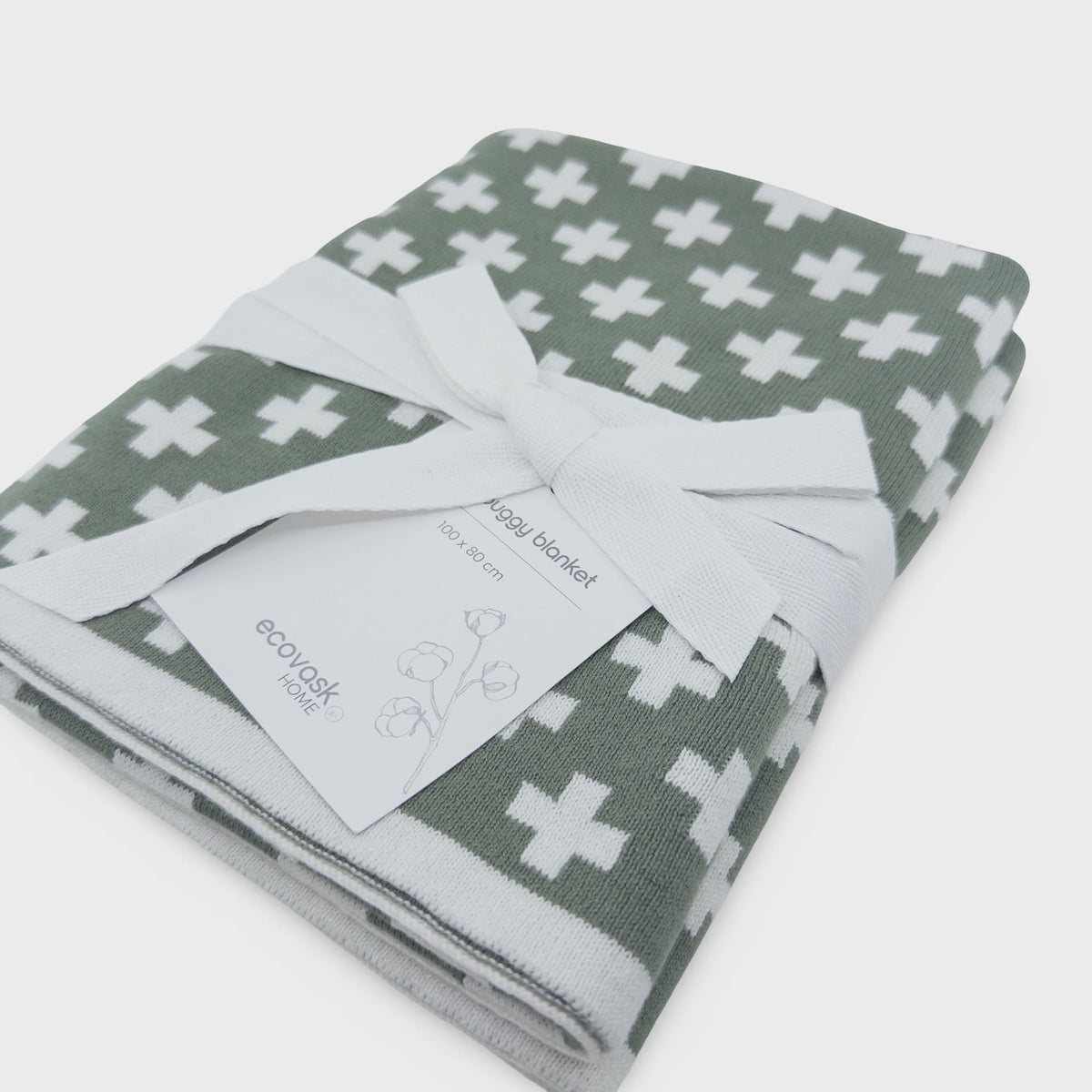Folded blanket with cross pattern and visible brand tag on a white background