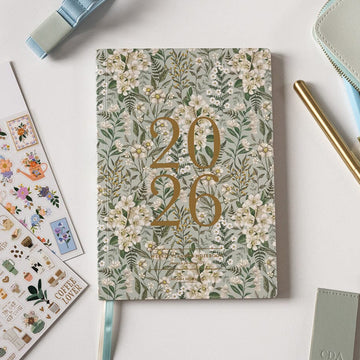 Floral notebook with '2026' design on a light surface with stationery items.