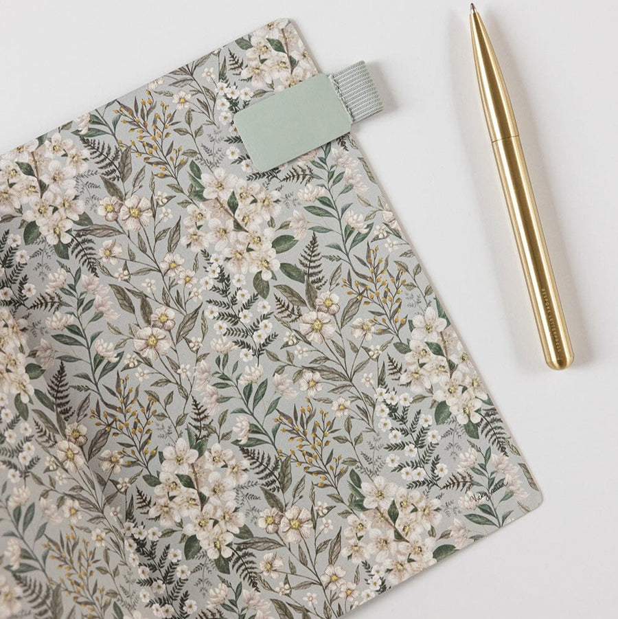 Floral notebook with a gold pen on a white background