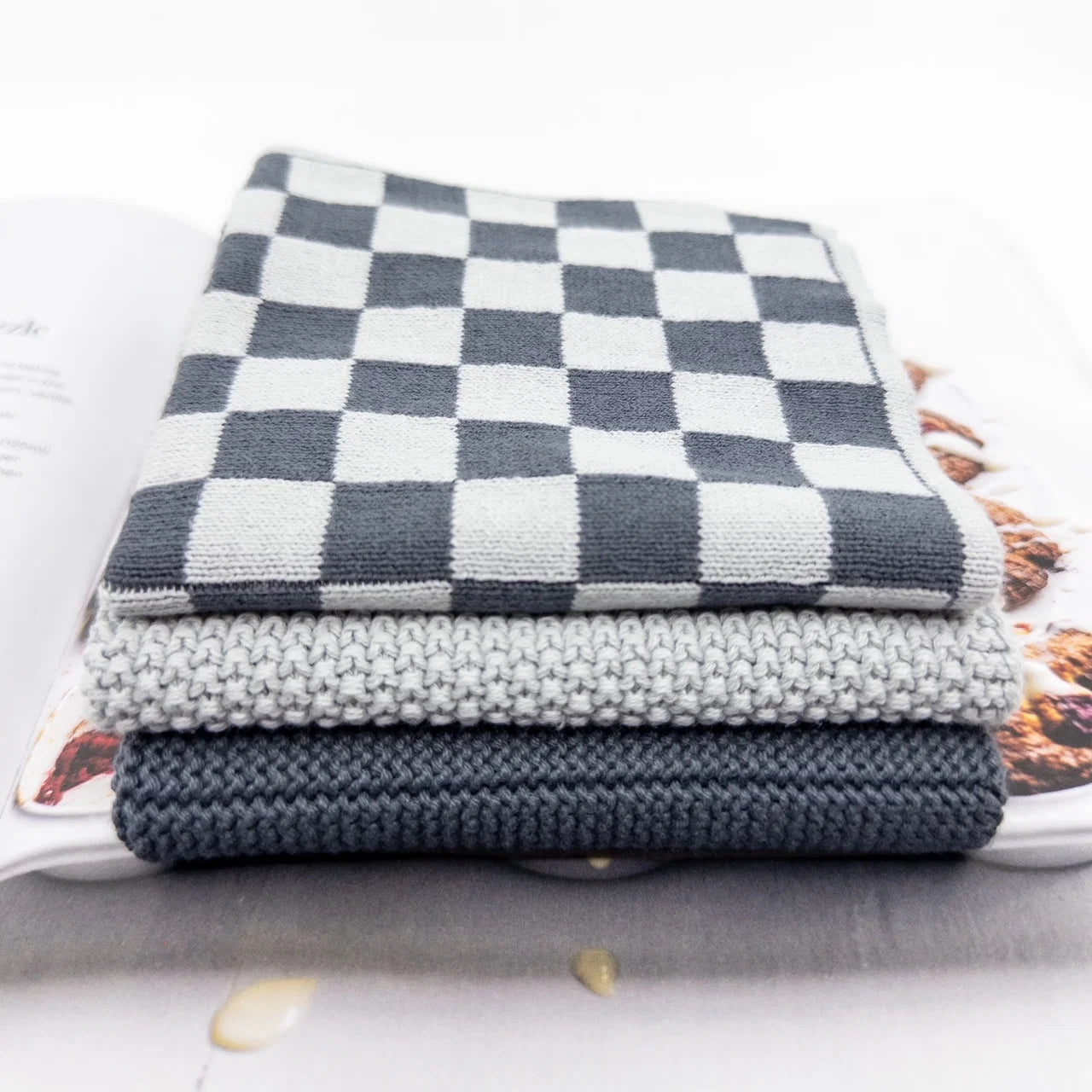 Stack of gray and white checkered fabric on a surface with a blurred background
