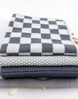 Stack of gray and white checkered fabric on a surface with a blurred background