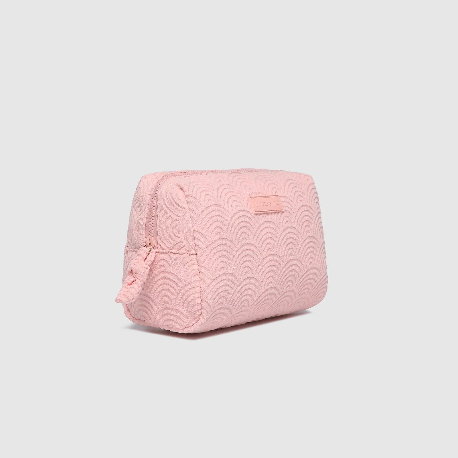Pink quilted cosmetic bag on a light gray background