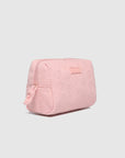 Pink quilted cosmetic bag on a light gray background